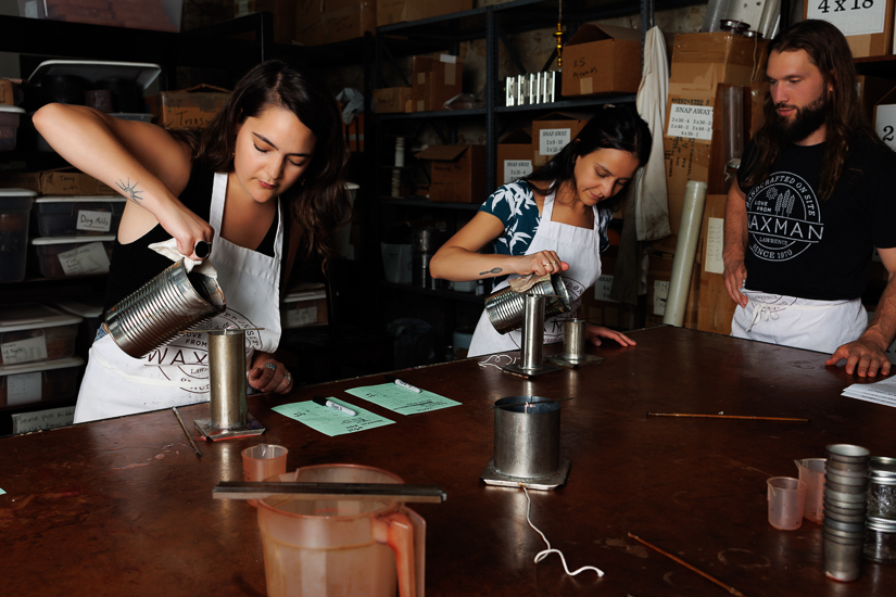 Class instructor, Ryder, watches over two participants while making candles in Waxman's studio.